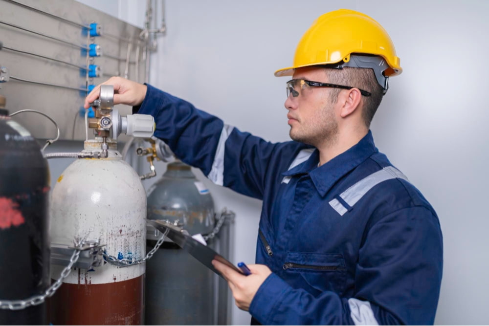Gas technician london inspecting high-pressure cylinders while wearing safety gear and helmet